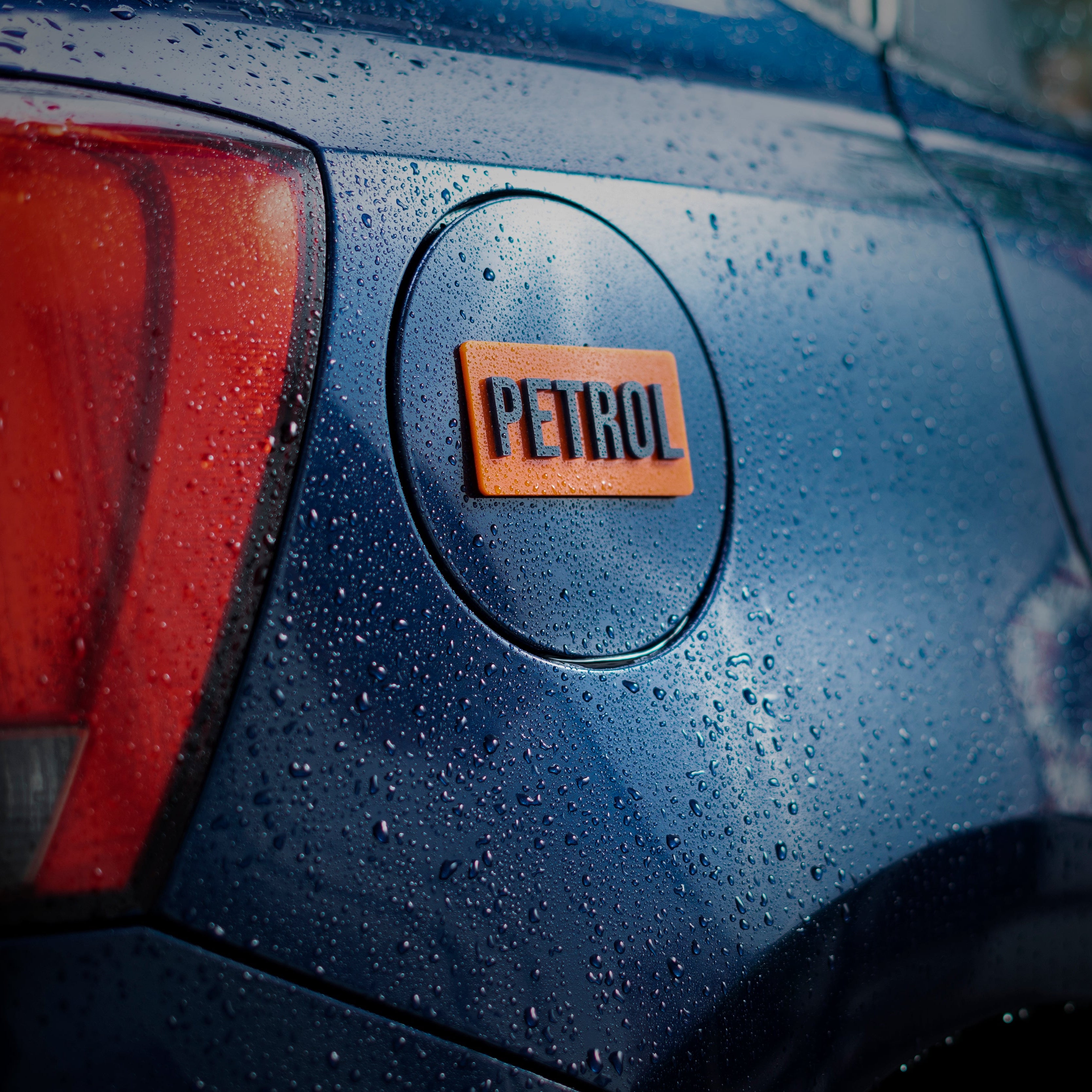 Car with a 'Petrol' badge on a wet surface