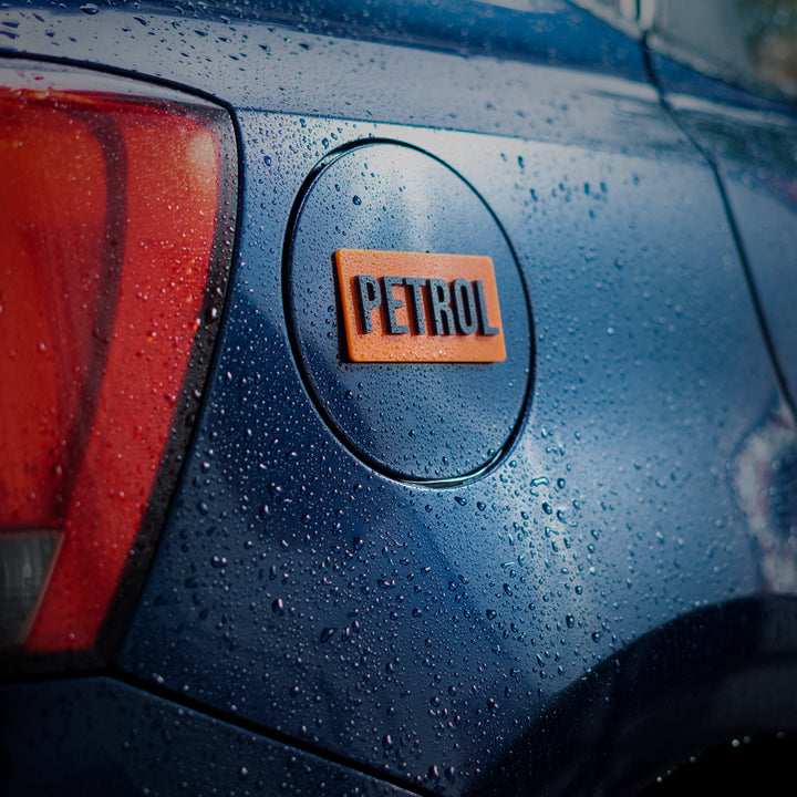 Car with a 'Petrol' badge on a wet surface