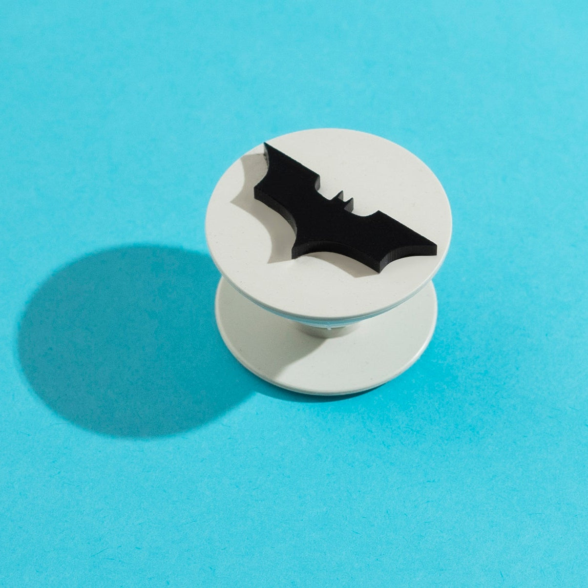 Phone grip with bat design on a light blue background