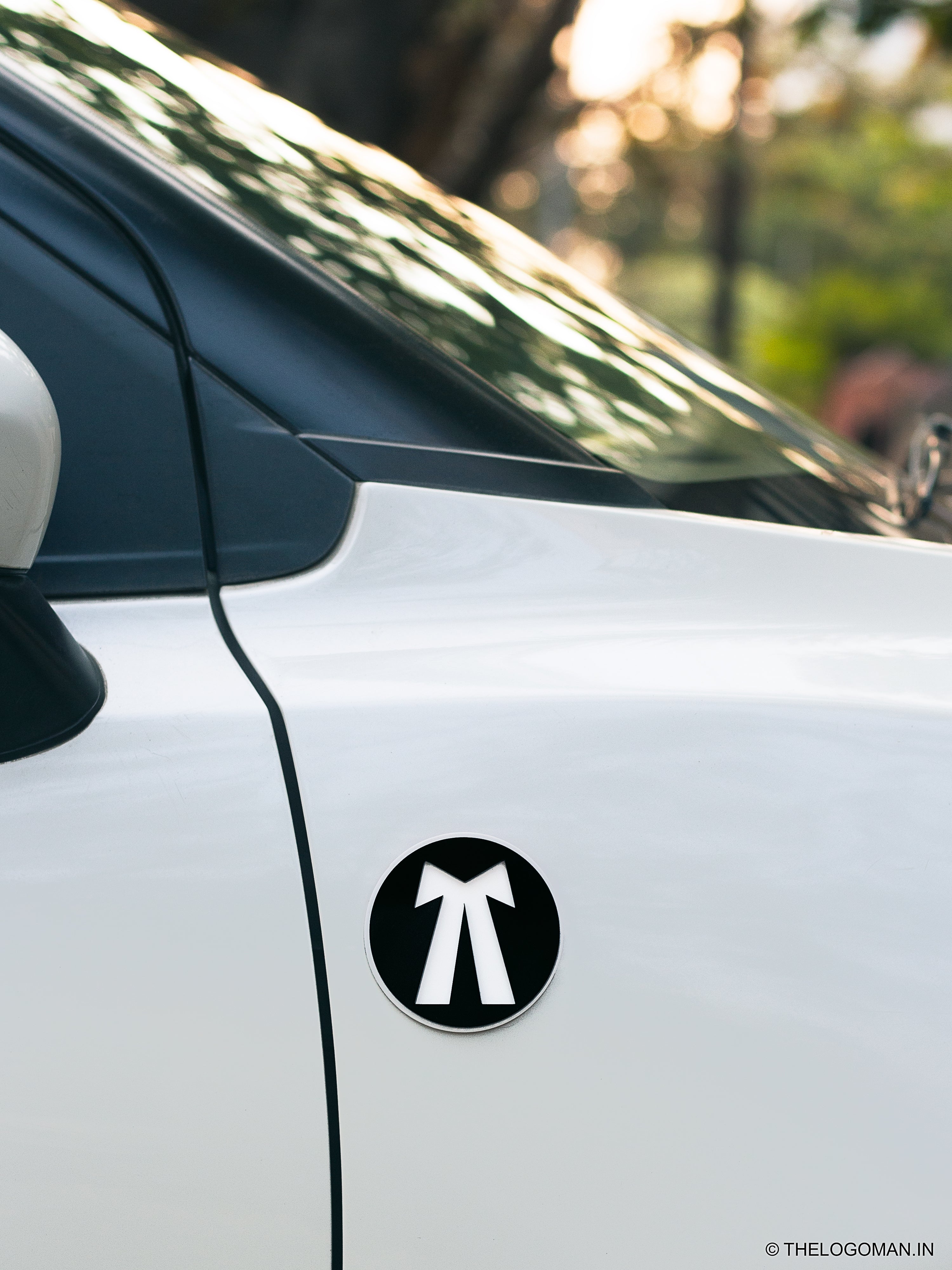 Car with a black and white logo decal on a white background