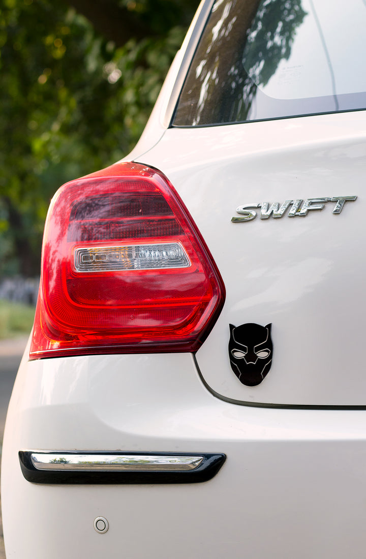 White car with 'Swift' branding and a black panther emblem on the trunk.