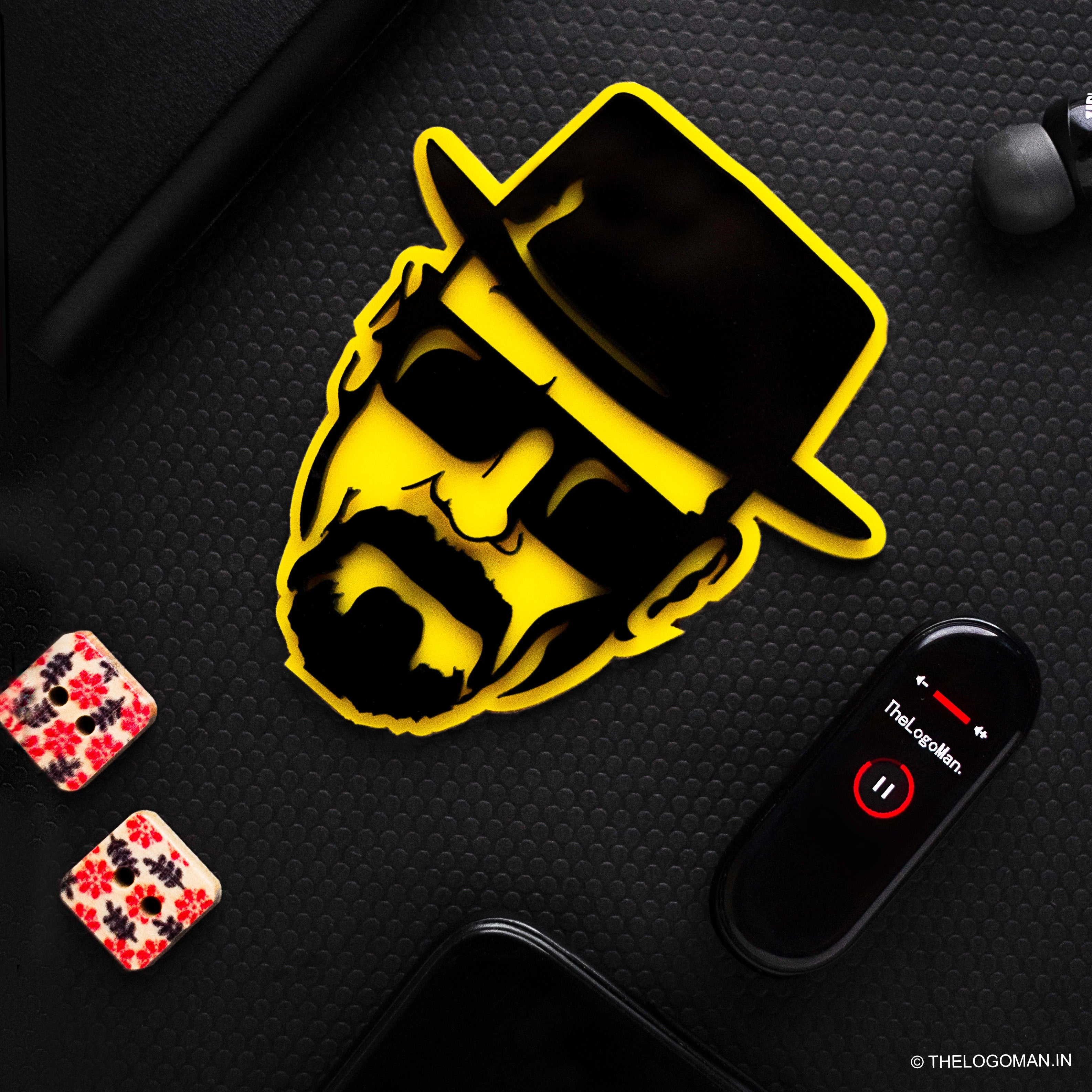 Yellow and black logo on a dark textured surface with a phone and earbuds.