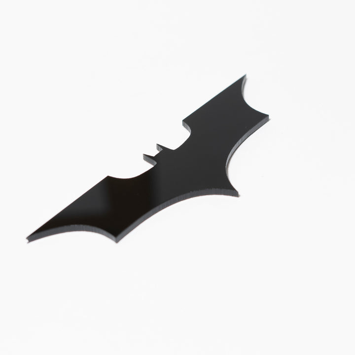 Black bat-shaped logo on a white background